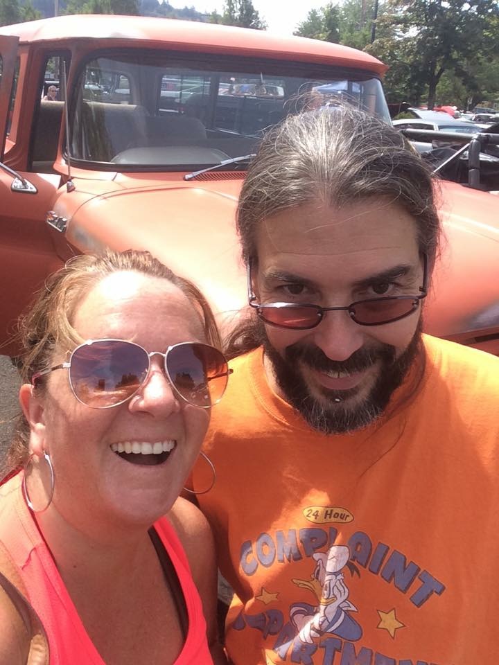 Couple in front of an orange classic Chevrolet truck