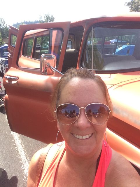 1962 Chevrolet Suburban - A woman takes a selfie in front of a vintage orange Chevrolet Suburban with the driver's side door open. The vehicle appears to be at an ou…
