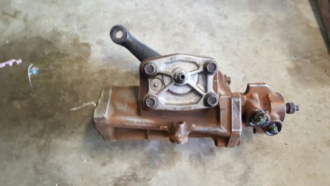 1996 Ford Bronco - A used power steering gearbox is shown from the side on a concrete surface.