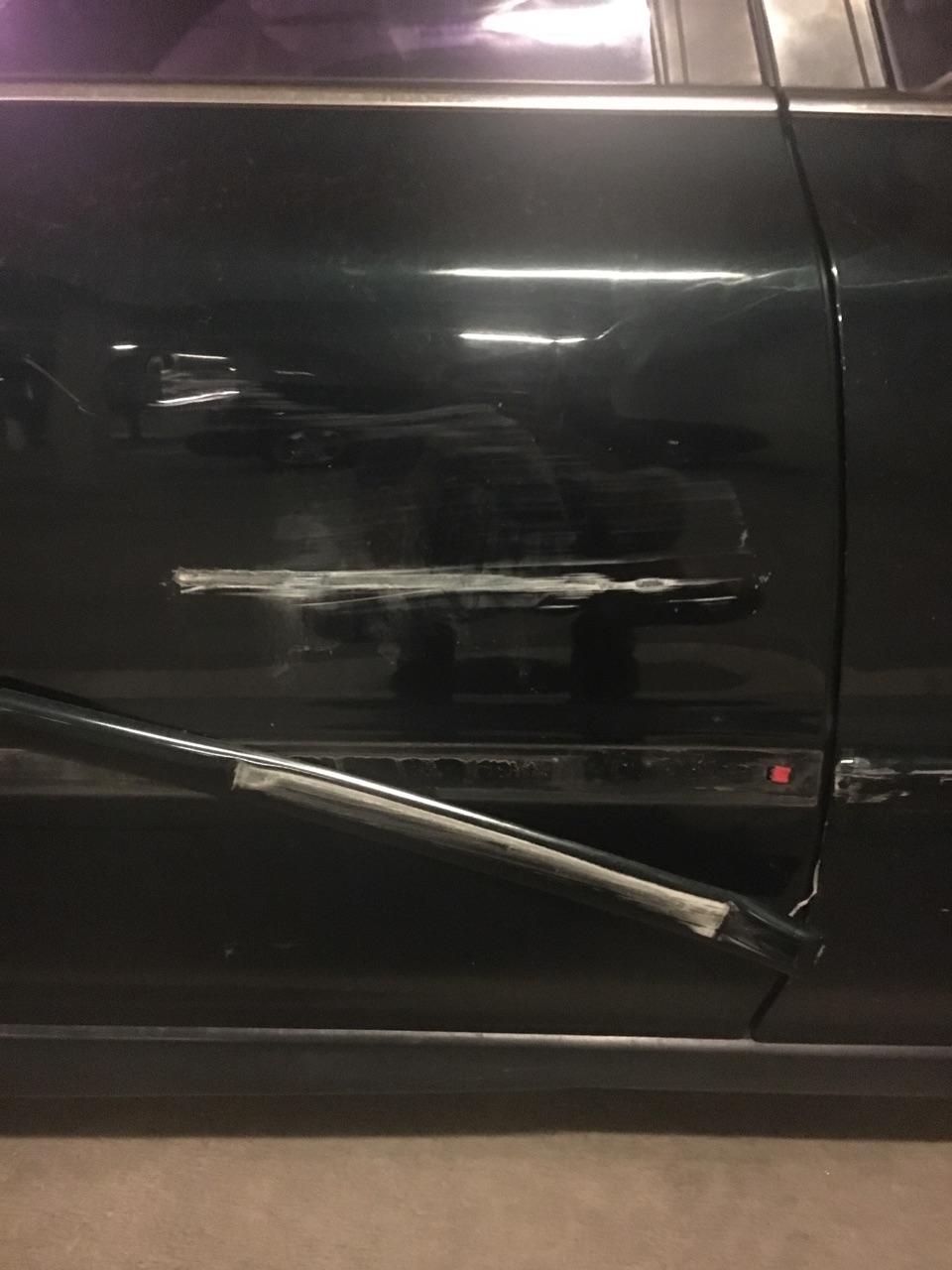Dark green car door with visible damage and repair attempts