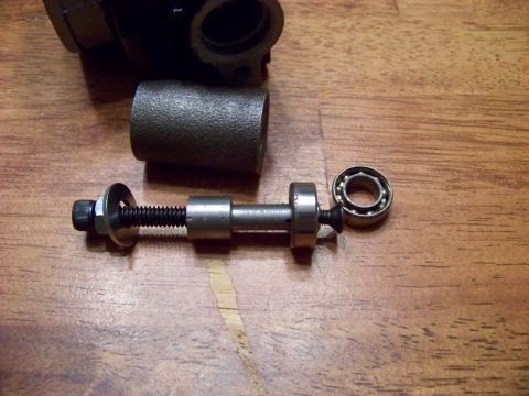 1999 Mercury Grand Marquis - A close-up view of disassembled automotive parts, including a bolt with washers and a bearing, resting on a wooden surface.