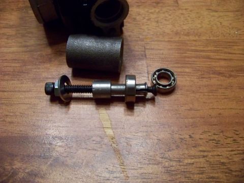 1999 Mercury Grand Marquis - A disassembled bicycle bottom bracket assembly with a bearing is shown on a wooden surface. The assembly includes a threaded spindle with n…