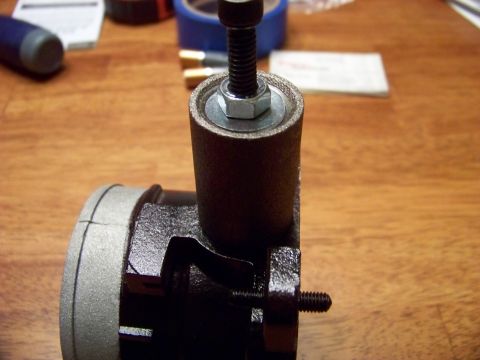 1999 Mercury Grand Marquis - A close-up view of a sanding drum attachment with a bolt and nut securing it. The attachment is placed on a wooden surface with some tools…