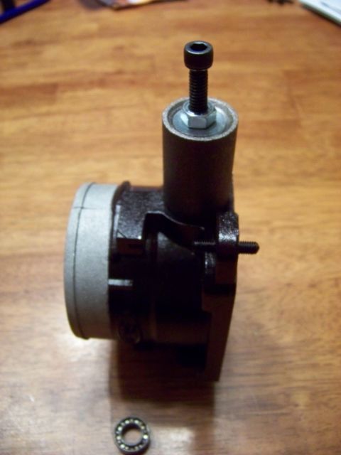 1999 Mercury Grand Marquis - A close-up shot of a small mechanical part, possibly a carburetor or fuel pump component, with a hex bolt and nut visible. A small ball bea…