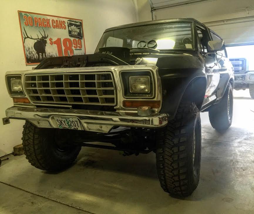 1979 Ford Bronco with hood open in a garage, Keystone Light sign on wall.
