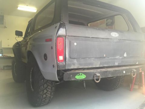 1979 Ford Bronco - The rear driver's side quarter panel of a classic Ford Bronco is shown in a garage setting. The vehicle has been modified with a custom rea…