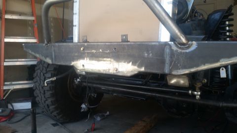 1979 Ford Bronco - Close-up of custom bumper and suspension components on a vehicle, with a large tire visible.