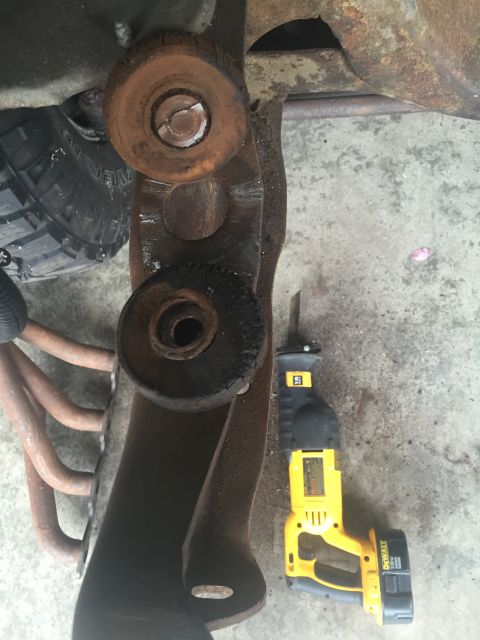 1978 Ford Bronco - Close-up of heavily rusted vehicle suspension components next to a yellow DeWalt reciprocating saw.