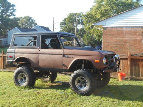 1972 Ford Bronco - This lifted 1972 Ford Bronco features a custom front bumper and visible roll cage, suggesting a restoration project.