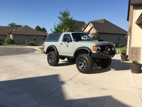 1988 Ford Bronco - This lifted 1988 Ford Bronco is parked in a suburban driveway on a sunny day.