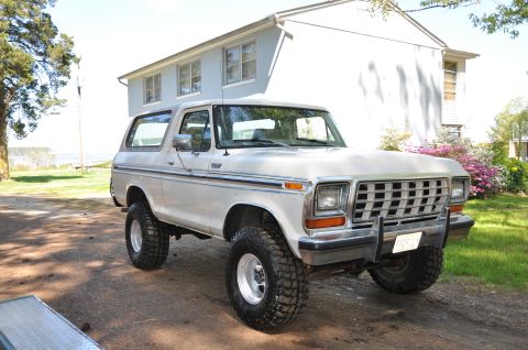 1979 Ford Bronco - White 1979 Ford Bronco with aftermarket wheels and tires sits outside a residential building.