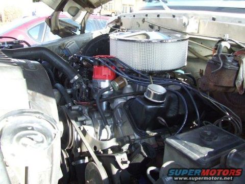 1979 Ford Bronco - Close-up view of the engine compartment, showing various engine components and a glimpse of another vehicle.