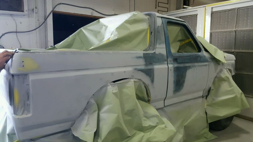 1988 Ford Bronco bodywork in primer, covered in masking paper for paint prep