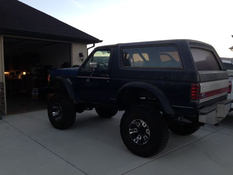 1988 Ford Bronco - This lifted 1988 Ford Bronco is shown in a three-quarter rear view, parked in a driveway.