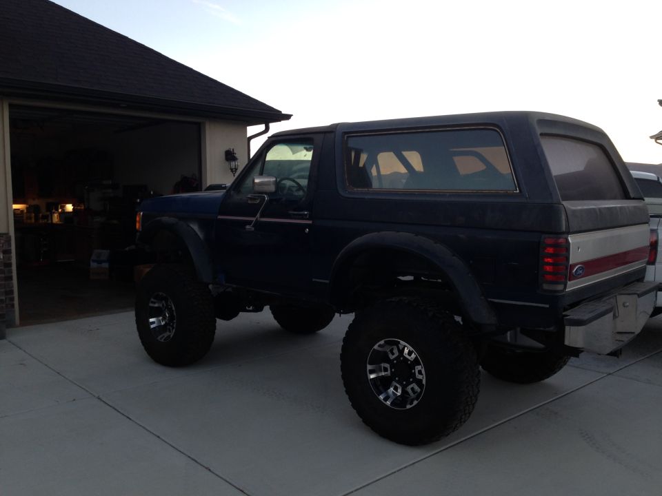 Dark blue lifted 1988 Ford Bronco, rear three-quarter view
