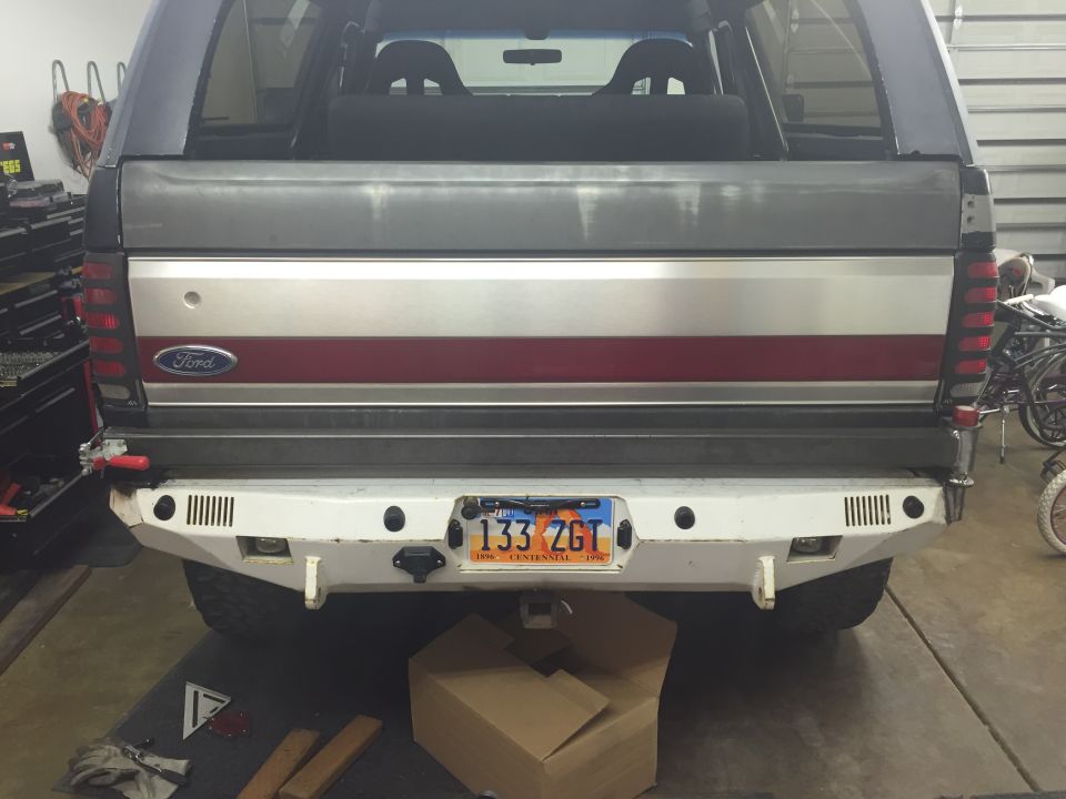 Rear view of a Ford Bronco with a custom white bumper and a license plate reading 133 ZGT