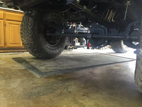 1988 Ford Bronco - Close-up view of a vehicle's undercarriage, focusing on the axle and tire assembly.