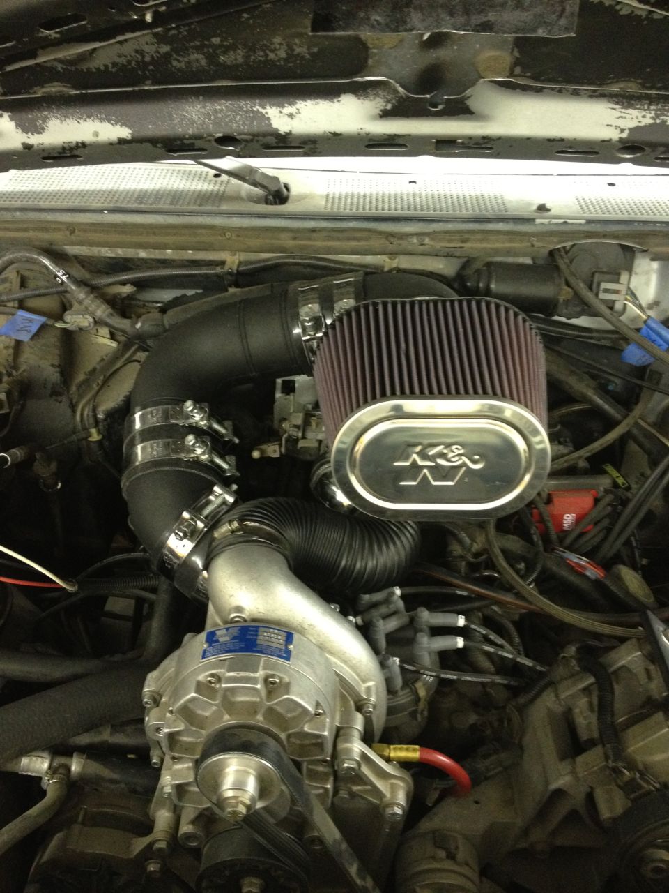 engine bay with K&N air filter, supercharger, and intake piping