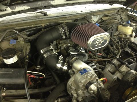 1988 Ford Bronco - Close-up view of a vehicle's engine bay, a K&N air filter and a prominent supercharger.