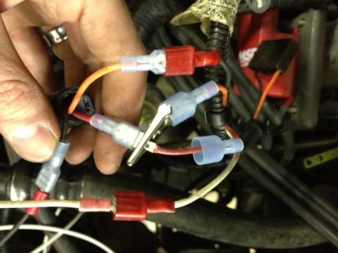 1988 Ford Bronco - A hand manipulates electrical connections within a vehicle's engine compartment, showing various wires and connectors.