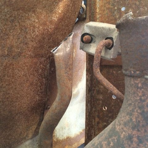 1988 Ford Bronco - This image shows heavily rusted metal components, likely from a vehicle's undercarriage or exhaust system.