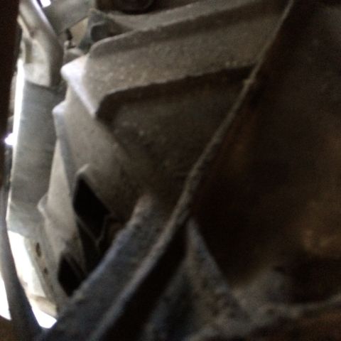 1988 Ford Bronco - Close-up of an exhaust system part, showing metallic texture and openings.