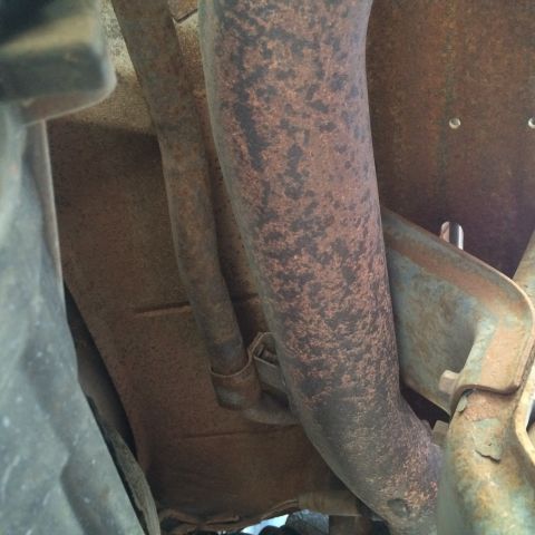 1988 Ford Bronco - Close-up view of rusted exhaust pipes, likely from the underside of a vehicle.