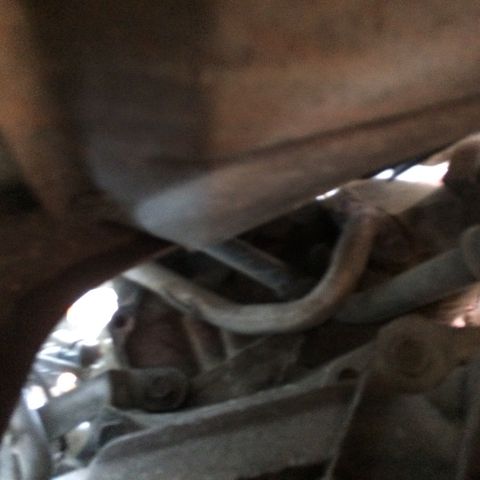 1988 Ford Bronco - Close-up of exhaust system parts, with website text visible at the bottom right.