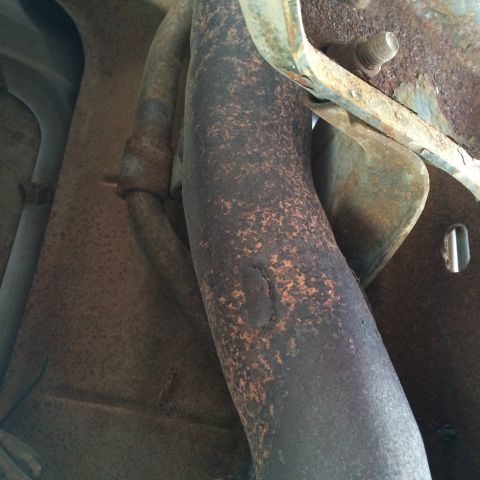 1988 Ford Bronco - Close-up of a corroded exhaust pipe, showing signs of wear and damage.