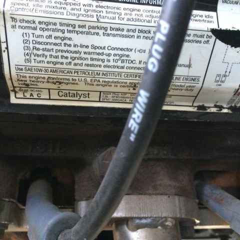 1988 Ford Bronco - Close-up of a spark plug wire and a label with engine timing instructions.