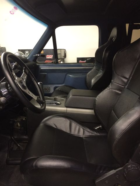 1988 Ford Bronco - Custom interior features racing seats and a modified steering wheel, with visible aftermarket parts on the dashboard.