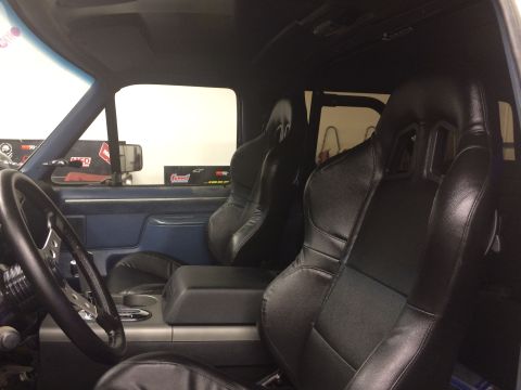 1988 Ford Bronco - Aftermarket racing seats and steering wheel installed in a vehicle's interior.
