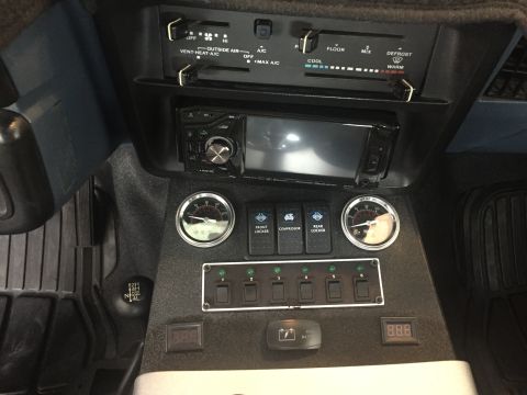 1988 Ford Bronco - Customized vehicle interior features auxiliary switches, gauges, and a digital display.