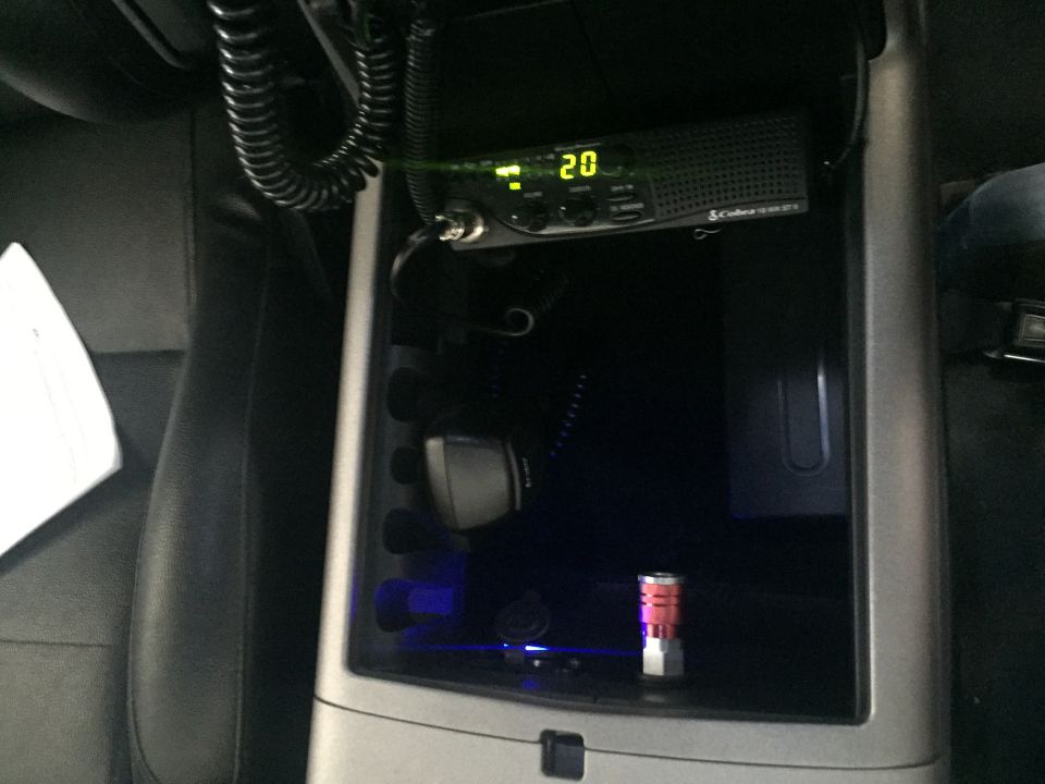Car interior showing a Cobra CB radio and microphone, with blue ambient lighting