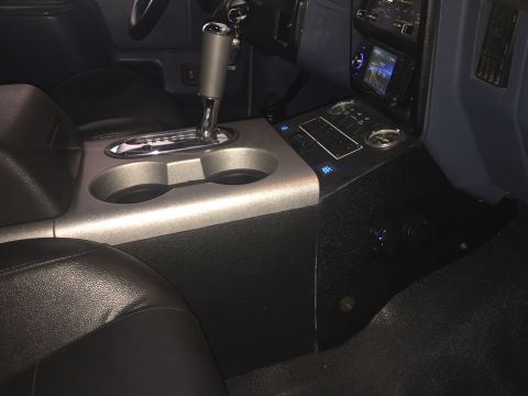 1988 Ford Bronco - The interior features an automatic shifter, dual cup holders, and a modern infotainment system.