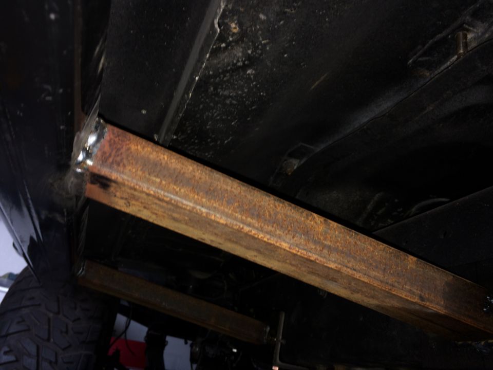 welded steel rock sliders on underside of vehicle, tire visible