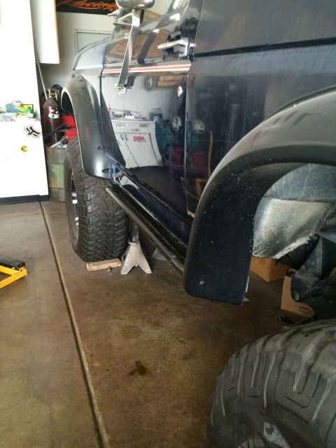 1988 Ford Bronco - A black SUV is shown from the side, supported by jack stands, with large off-road tires visible.