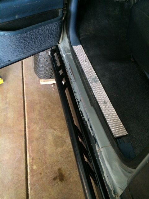 1988 Ford Bronco - Aftermarket rock sliders and a diamond plate door sill are visible inside a vehicle's cabin.