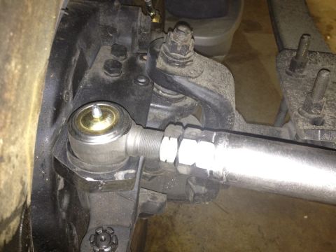 1988 Ford Bronco - A close-up view shows the steering linkage of a vehicle, specifically a tie rod end connected to the steering knuckle. The components are d…