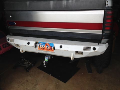 1988 Ford Bronco - The rear of a white custom bumper is shown, mounted to a vehicle with a silver and red stripe tailgate. A Utah license plate reading "133 Z…
