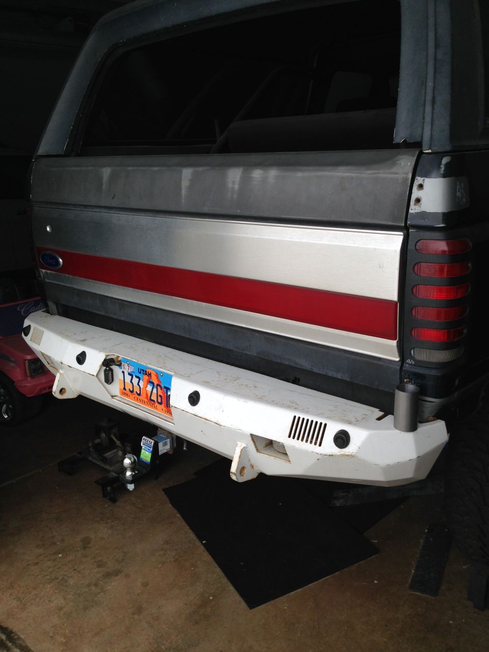 Rear view of a Ford Bronco with a custom white bumper and Utah license plate.