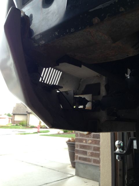 1988 Ford Bronco - Underside view of a vehicle's rear bumper and hitch receiver, showing some rust and modifications to the bumper structure.