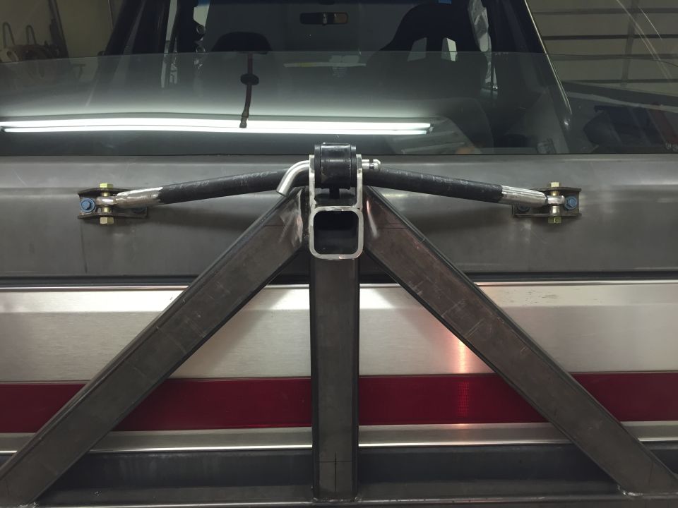 Custom swing-away spare tire carrier mounted on a vehicle tailgate.