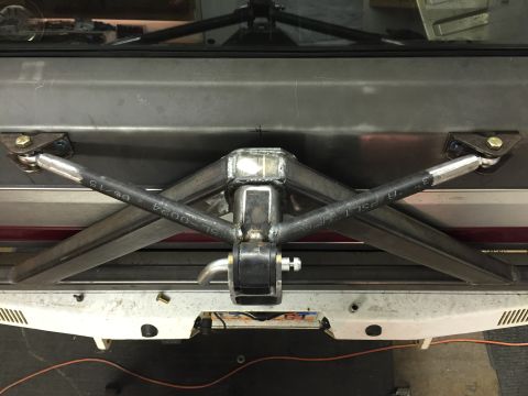 1988 Ford Bronco - A custom fabricated X-brace is mounted to the underside of a vehicle, likely a truck or SUV, connecting to the frame with adjustable rod en…