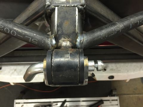 1988 Ford Bronco - Close-up view of a suspension component, likely part of a sway bar or control arm, mounted to a metal frame. The component features a black…