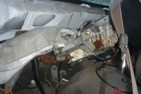 1988 Ford Bronco - The interior of a vehicle shows a disassembled dashboard with the steering column and ignition components exposed. Wires and metal brackets…