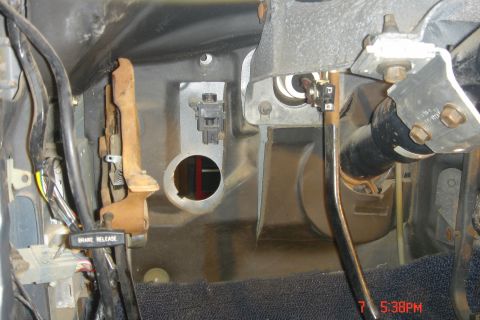 1988 Ford Bronco - The interior of a vehicle's footwell shows the brake pedal assembly, a brake release lever with text, and various wiring harnesses and comp…