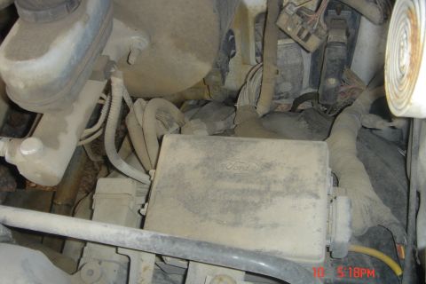 1988 Ford Bronco - The image shows a close-up view of the engine bay of a vehicle, focusing on the fuse box and brake fluid reservoir. The fuse box has the Fo…