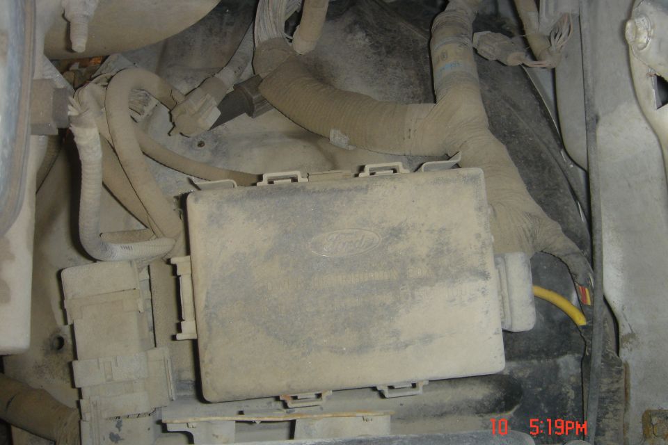 Dusty Ford fuse box with wiring in engine bay
