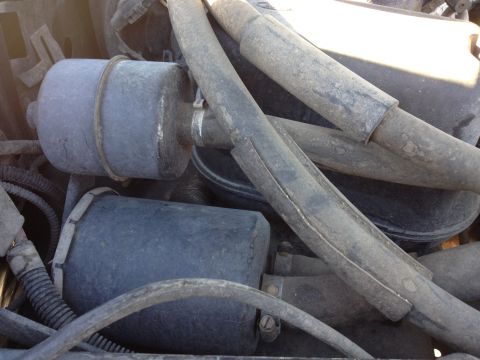 1988 Ford Bronco - A close-up view of engine components in a 1988 Ford Bronco, showing several dark-colored hoses and filters.